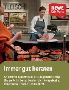 Mitarbeiterin bedient eine Kundin an der Fleischtheke eines REWE-Marktes