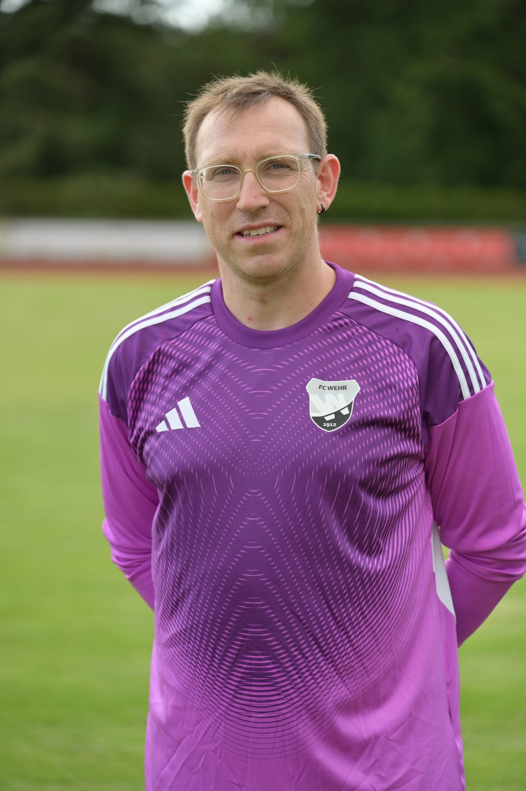 Porträtfoto eines Trainers der E-Junioren des FC Wehr 1912 mit Brille in violettem Trikot