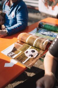 Besucher sortiert StickerStars-2026-Sticker an einem Tisch bei der Sammelaktion