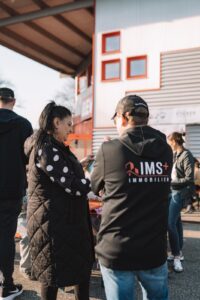 Besucher vor der Fassade des REWE-Marktes während der StickerStars-2026-Aktion