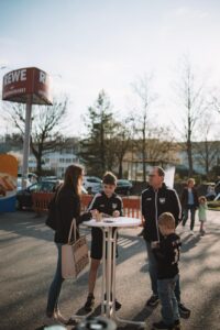 REWE-Schriftzug am Getränkemarkt vor blauem Himmel
