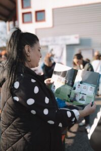 Impressionsaufnahme einer Besucherin vor dem REWE-Markt während der StickerStars-2026-Aktion