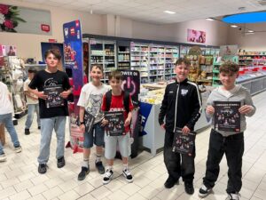 Kinder präsentieren ihre fertigen 'Wehrer Stars 2026'-Sticheralben im REWE-Markt