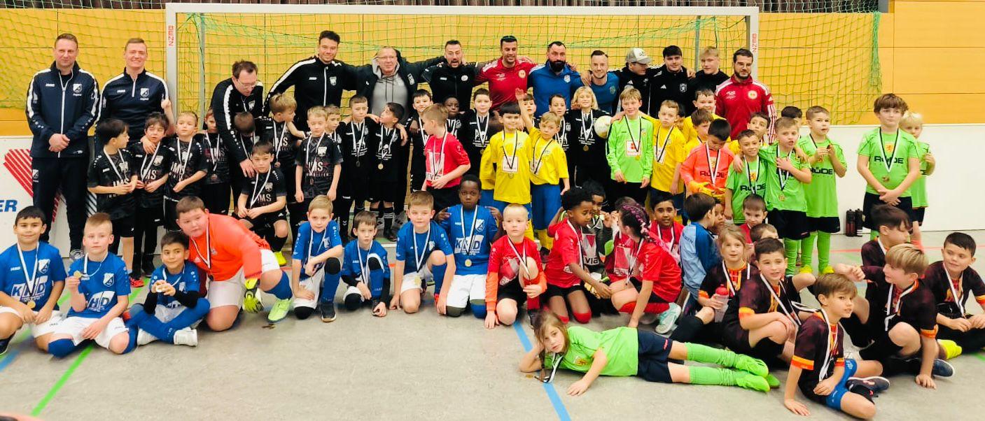 Großes Gruppenfoto mehrerer Nachwuchsmannschaften mit Medaillen nach einem Hallenturnier